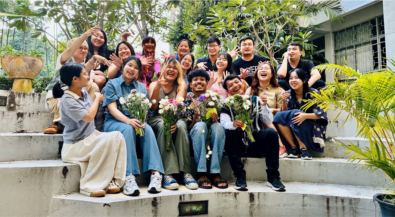 Friends and volunteers gather on steps outside posing for photo.